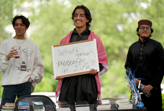 Bilal Zafar, of the Texas Muslim Students Association, talks to passers by at the 3rd Annual Eid Celebration and Friday Prayer at the Capitol Friday April 19, 2024. Every year after Muslims finish fasting for a month during Ramadan, they gather for Eid al-Fitr, the festival of breaking the fast. The event had Middle Eastern food, henna design, Arabic calligraphy and an art display.