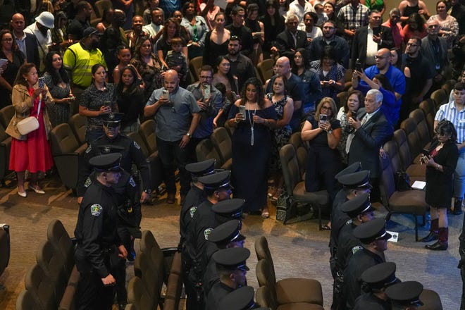 Family and friends take photos at the graduation ceremony for the Austin Police Department’s 151st Cadet Class at Bannockburn Church on Friday, April 19, 2024 in Austin.