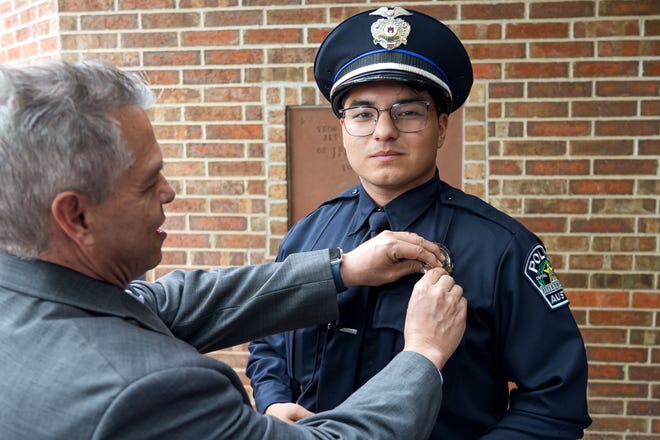 Graduating officer Jonathan Hernandez has his badge adjusted by gis girlfriend's father, Andy Large, after the graduation ceremony for the Austin Police Department’s 151st Cadet Class at Bannockburn Church on Friday, April 19, 2024 in Austin.