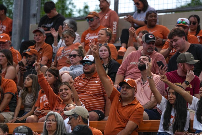 Texas Longhorns fans hold up the sign of the horns during the game against Iowa State at Red and Charline McCombs Field on Friday, April 26, 2024 in Austin.
